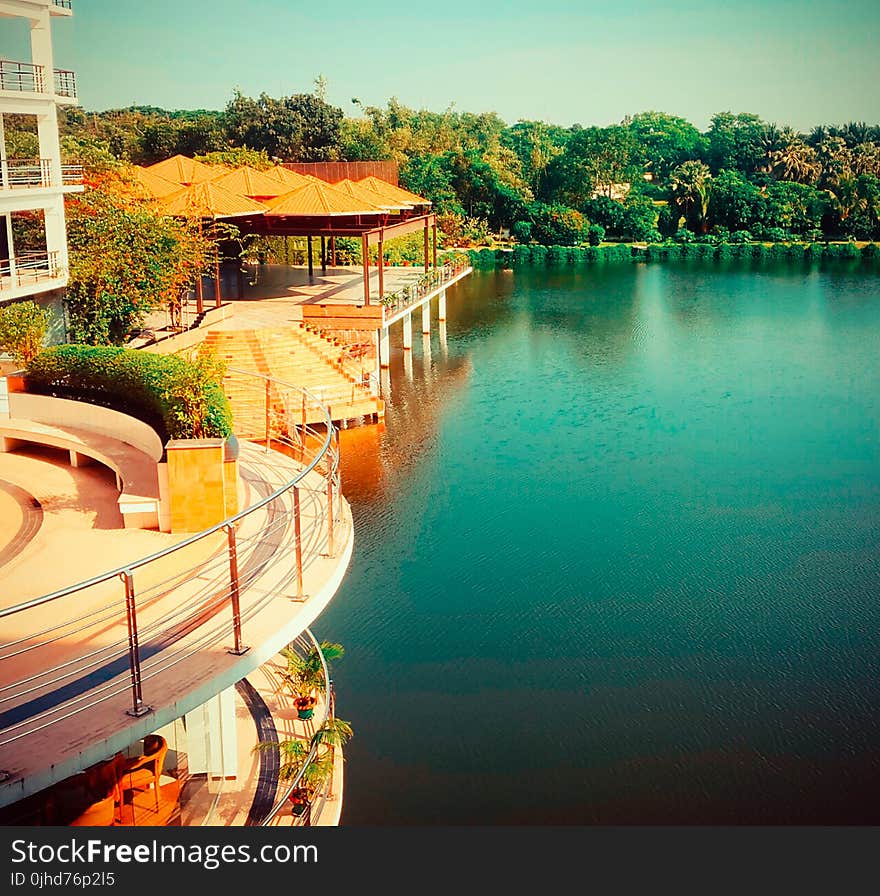 Brown Wooden House Beside Gazebos Near Body Of Water