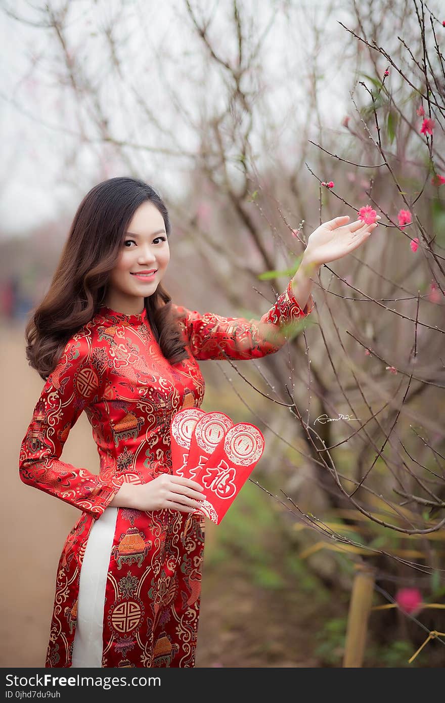 Woman Wearing Red Long-sleeved Dress Holding Pink Petaled Flower