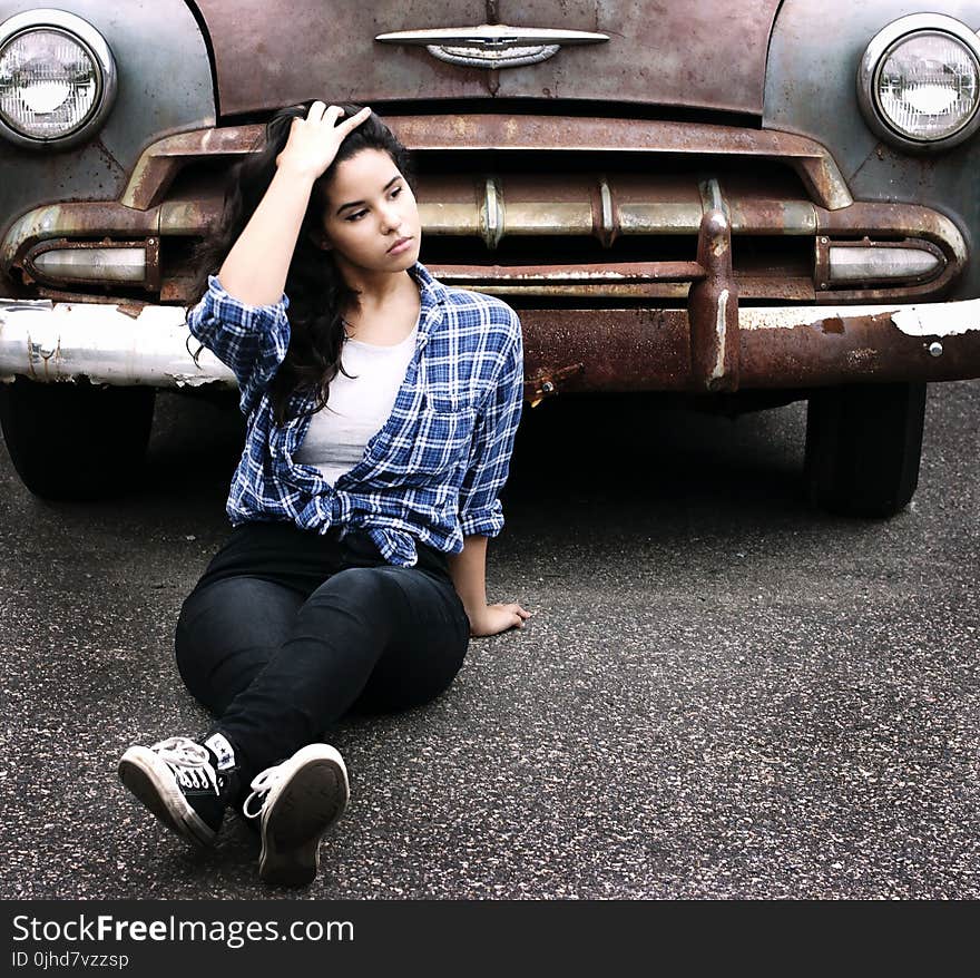 Woman in Blue Sports Shirt Sitting Infront of Vintage Brown Car