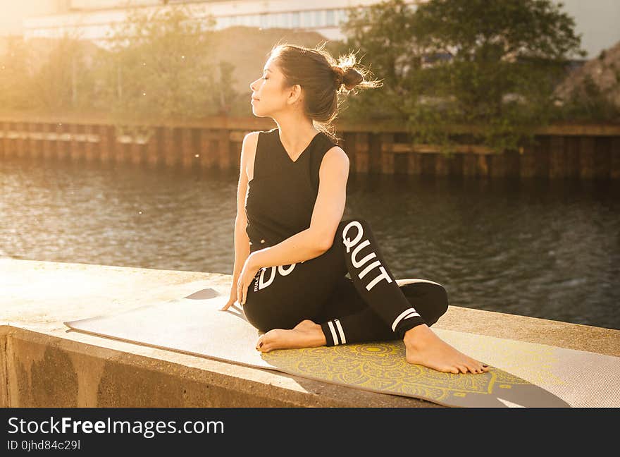 Woman Wearing Black Fitness Outfit Performs Yoga Near Body of Water