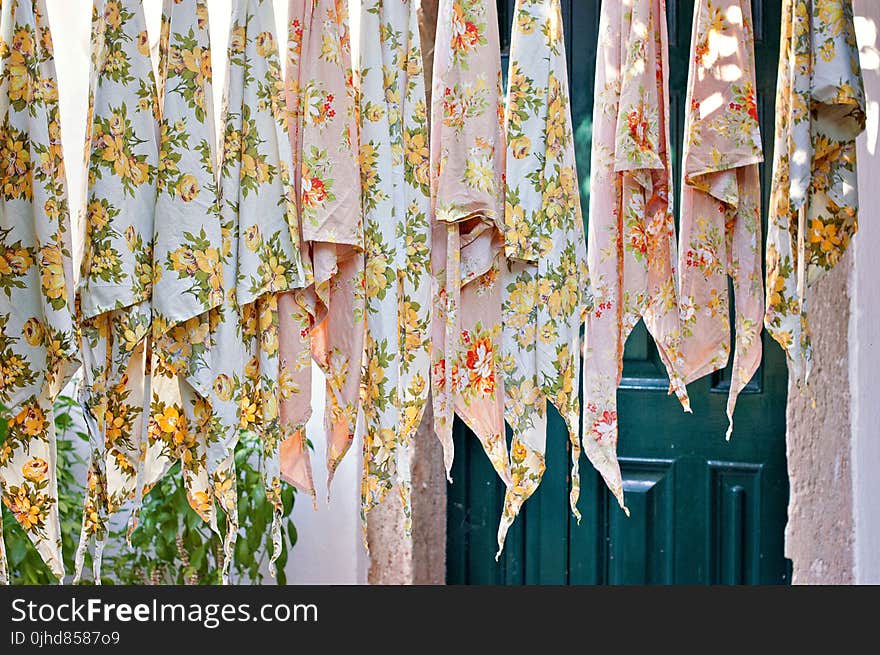 Assorted Textile Lot Hanging Beside Blue Wooden Door