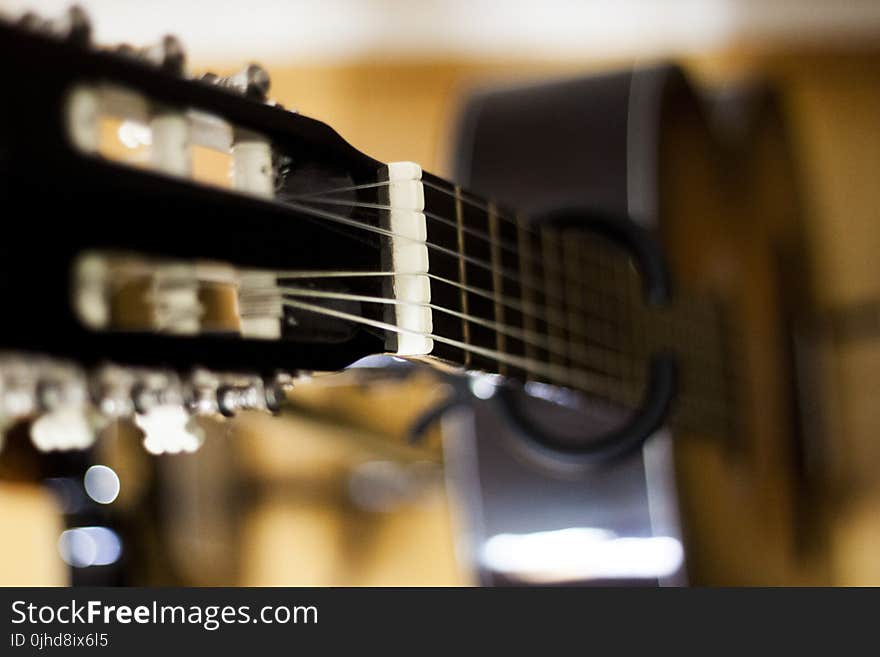 Selective Focus Photo of Black Classical Guitar