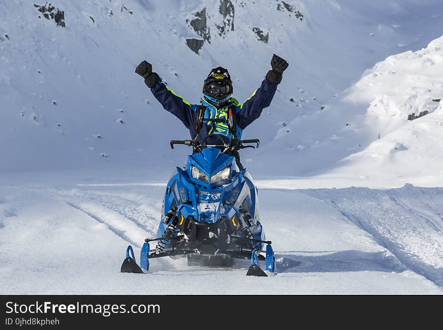 Person Riding Blue Snow Mobile