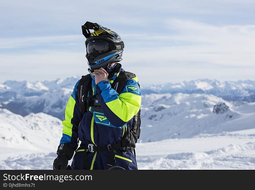 Man in Green and Blue Jacket Standing on Winter Season