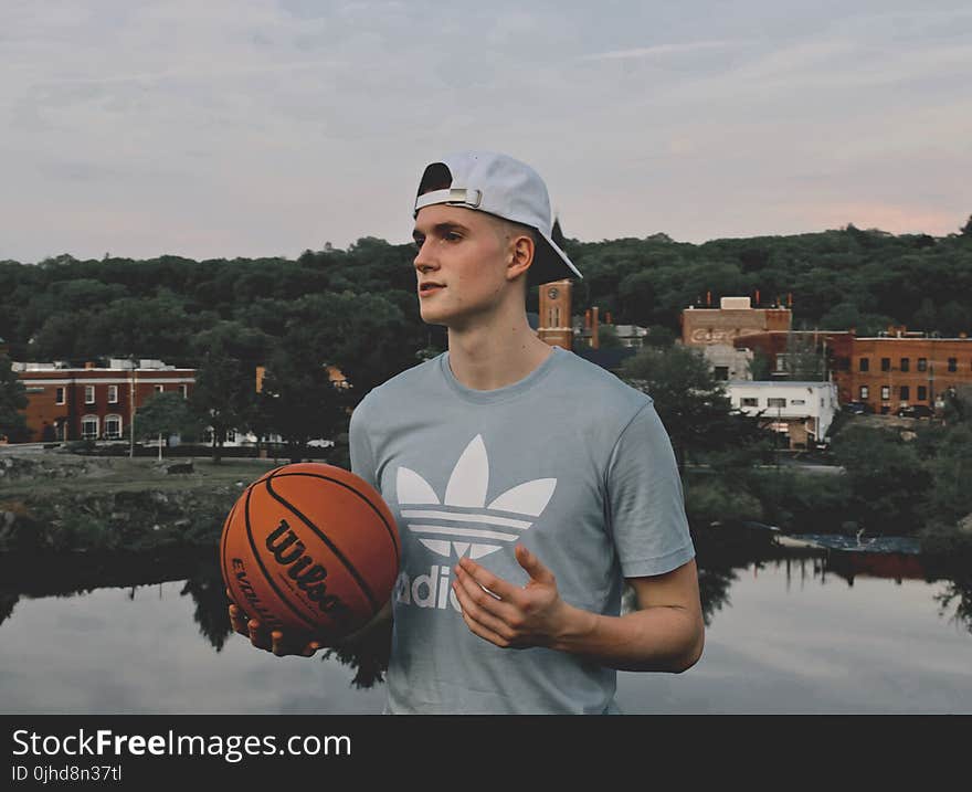 Man Wearing Gray Crew Neck Shirt Holding Basketball