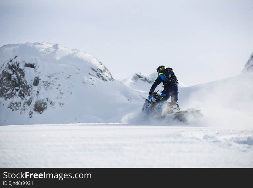 Person Riding on Snowmobile during Winter