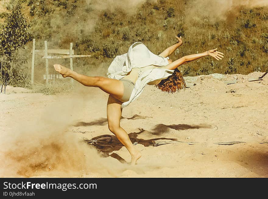 Woman Wearing White Dress Dancing on Brown Sand