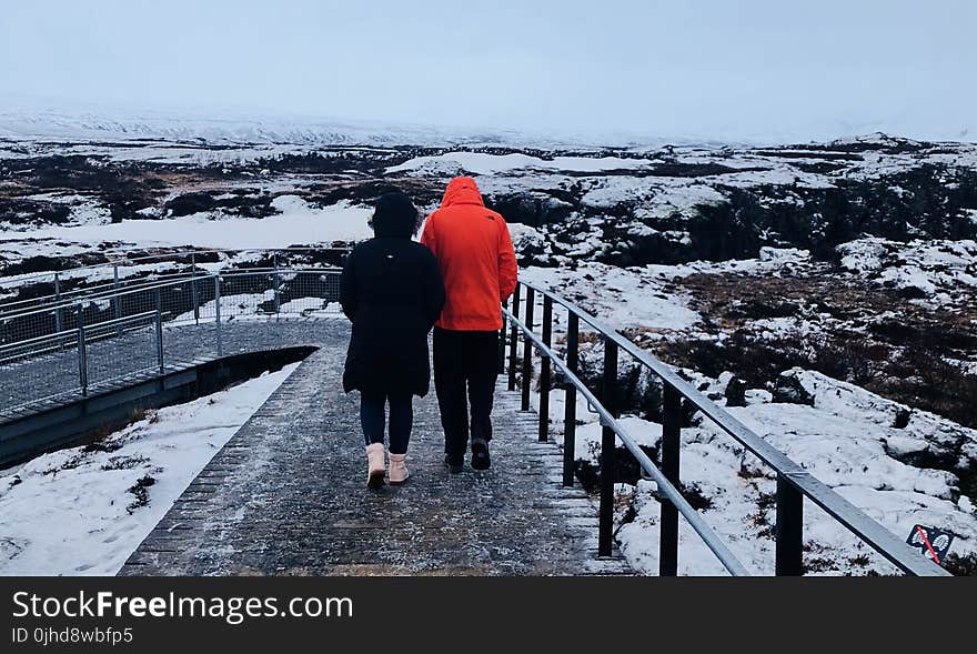 Two People Wearing Black And Red Winter Jackets