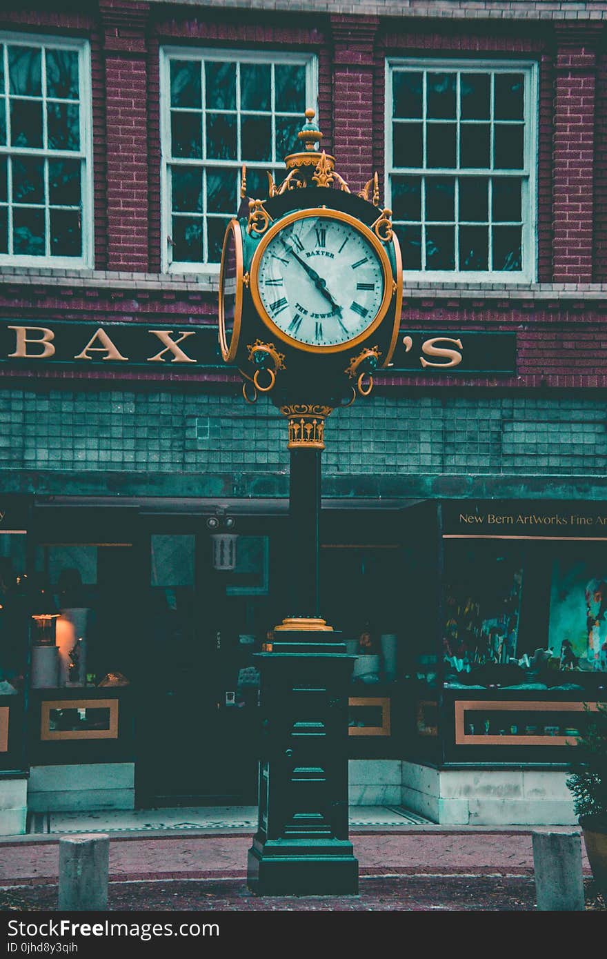 Round Yellow and Black Analog Pedestal Clock Displaying 4:58