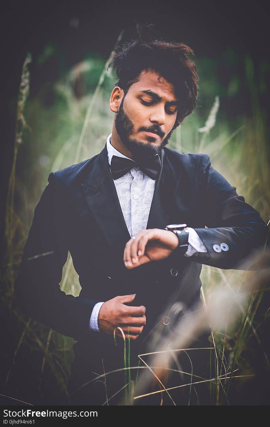 Man in Tuxedo Suit Surrounded by Grass