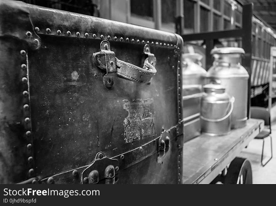 Grayscale Photography of Travel Case With Milk Churns on Trailer