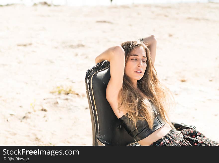 Woman Wearing Black Crop Top With Black Floral Bottoms Sitting on Chair