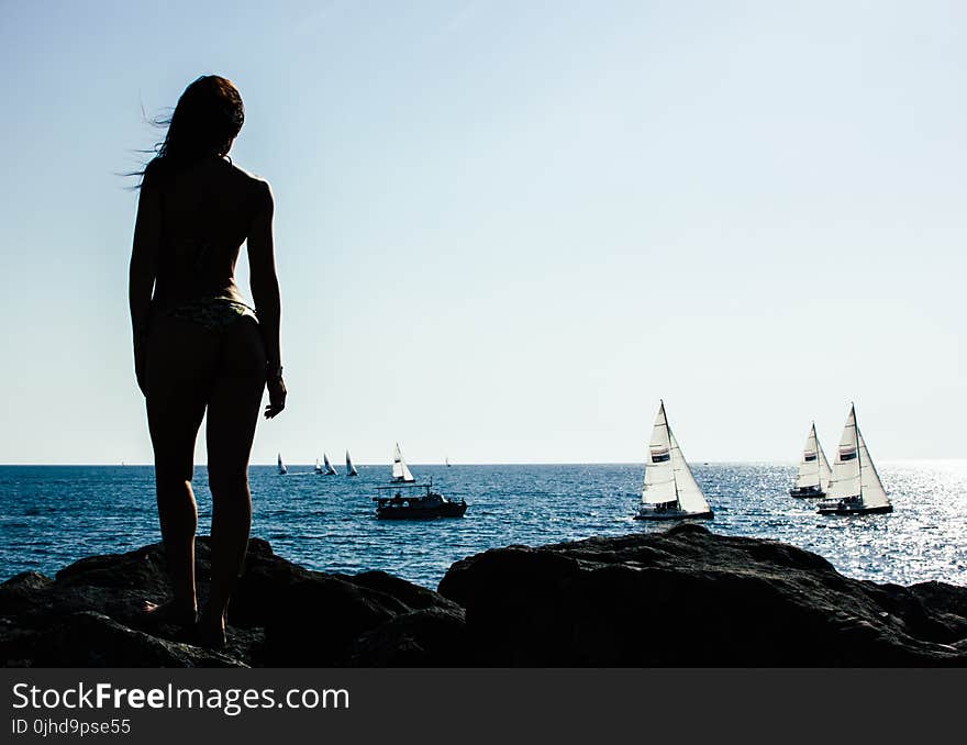 Woman Standing on Rock With Sailing Boats on Sea