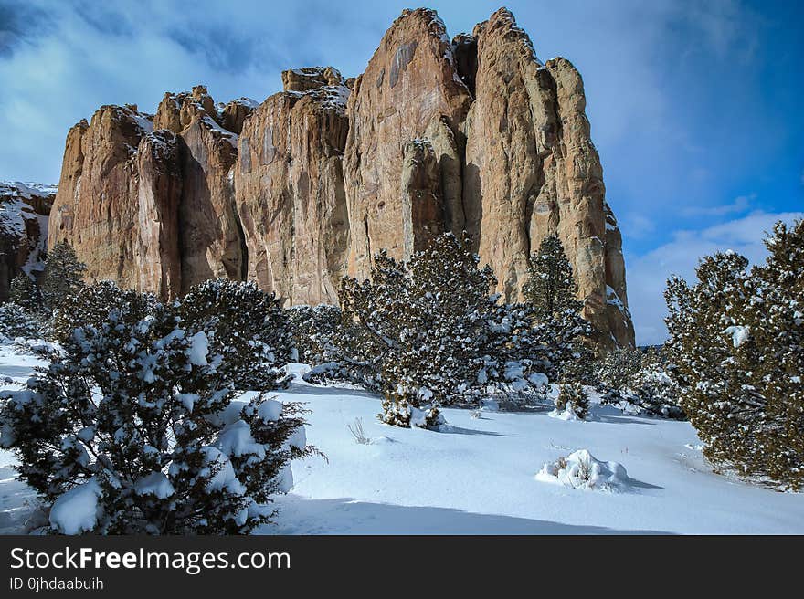 Landscape Photography of Brown Mountain Near Snowy Trees Under Cloudy Blue Sky