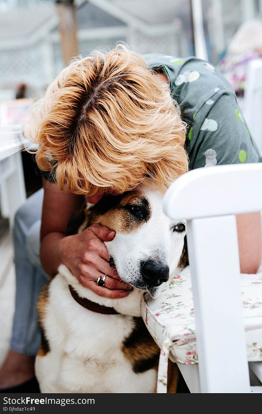 Boy in Gray Floral T-shirt Hugging White and Tan Dog