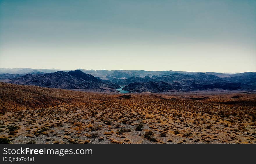 Brown Sand Near Mountain Under Cloudy Sky