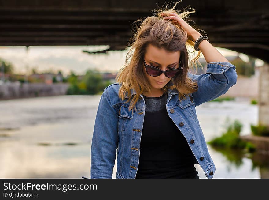 Close Up Photo of Woman Wearing Black Top and Blue Denim Button-up Jacket