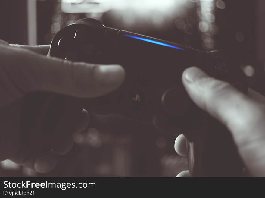 Black And White Photo Of Man Holding Sony Ps4 Wireless Controller