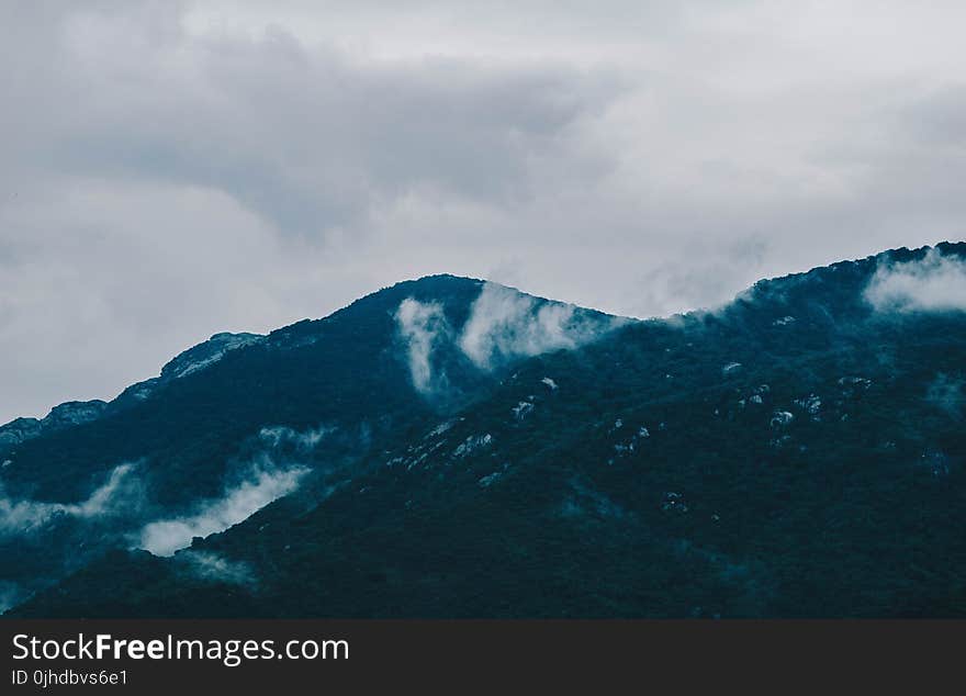 Photography of Mountain Under Cloudy Sky