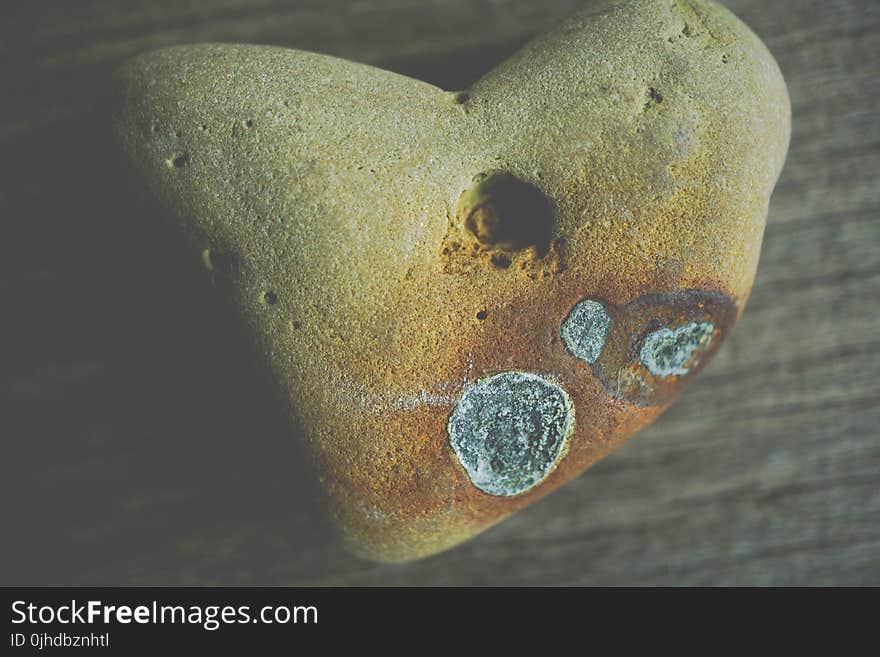 Beige Rock on Brown Wooden Surface