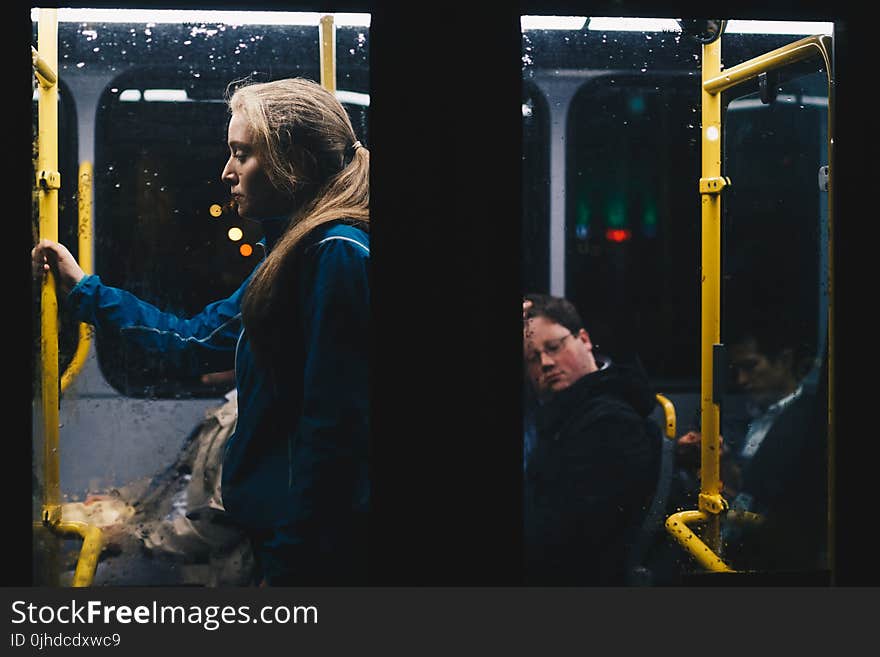 Photo of a Woman Standing Inside Bus