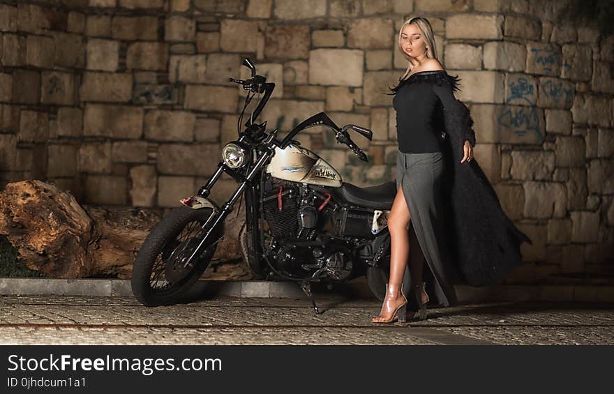 Woman In Black and Grey Long-sleeved Dress Standing Beside Cruiser Motorcycle