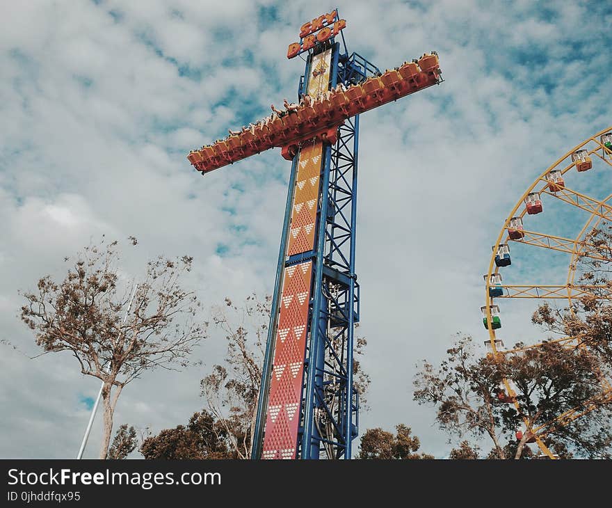 People Riding on Amusement Park Blue and Orange Sky Drop