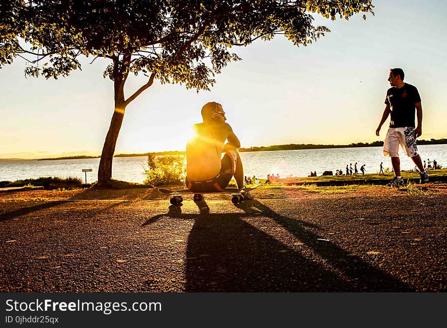 Photo of Man Sitting on Skateboard