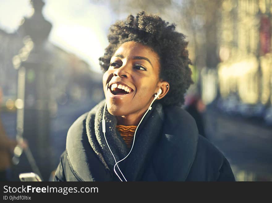 Close-up Photo of a Woman Listening to Music