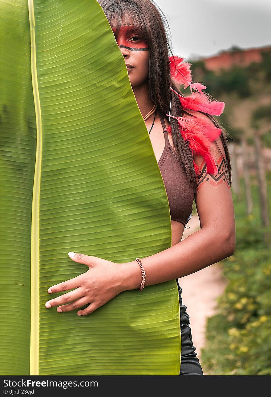 Woman in Brown Brassiere in Front of Banana Leaf