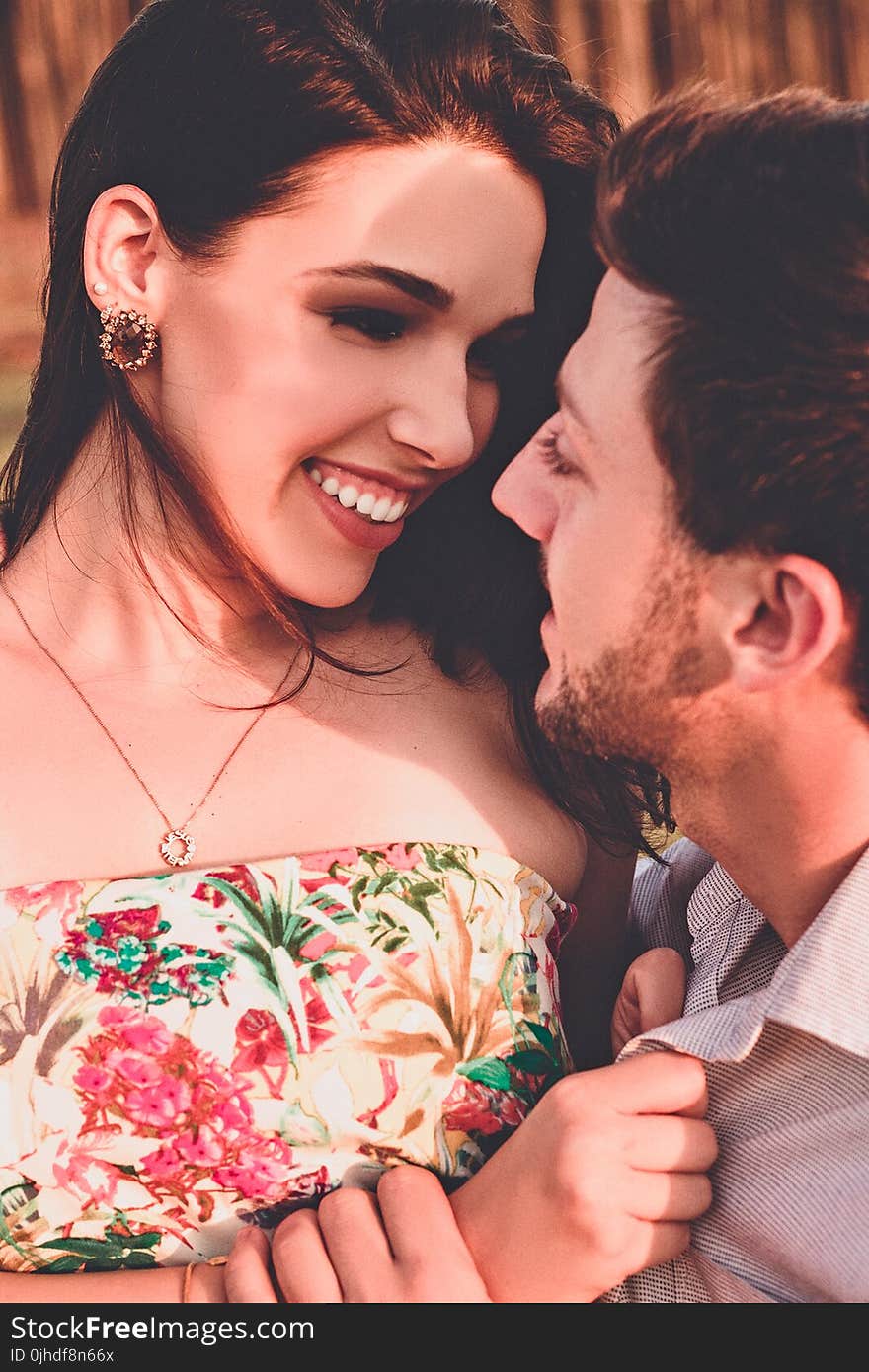 Woman In Floral Dress Looking At Man In Grey Collared Top