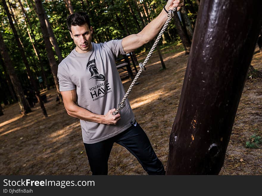 Photo of Man in Gray Shirt Holding Brown Rope