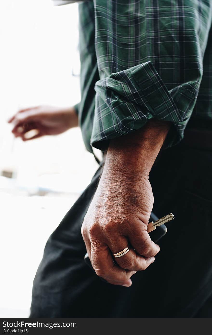 Person Holding a Silver-colored Key