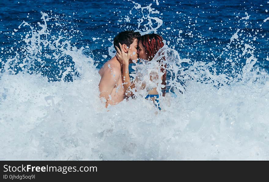 Couple Kissing While Waves Crash