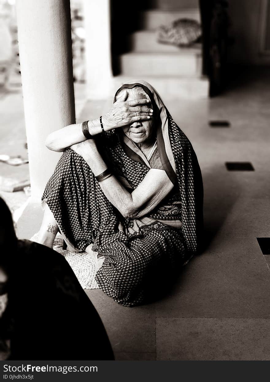 Gray Scale Photo of Woman Seat on Floor