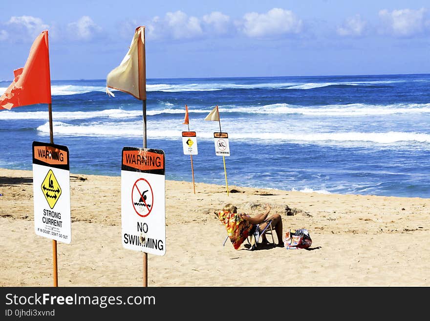 Men Sitting on White Folding Chair Bear Body of Water