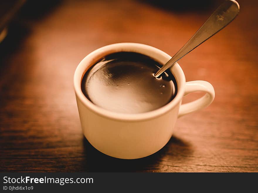 White Ceramic Espresso Cup Filled With Coffee On Brown Wooden Surface