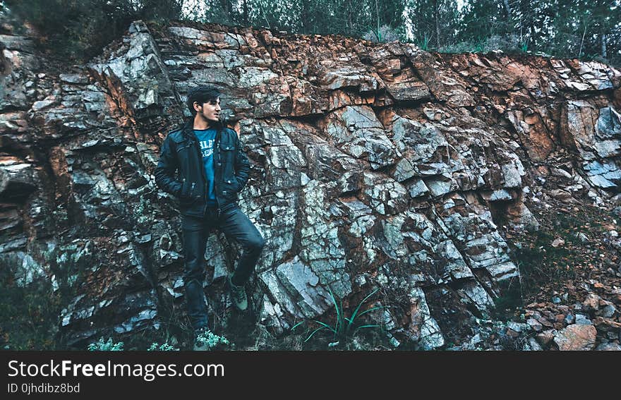 Man Wearing Jacket Standing in Stone Ledge