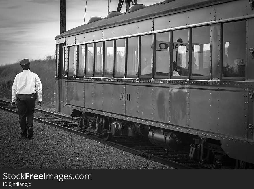 Greyscale Photography of Train Beside Woman