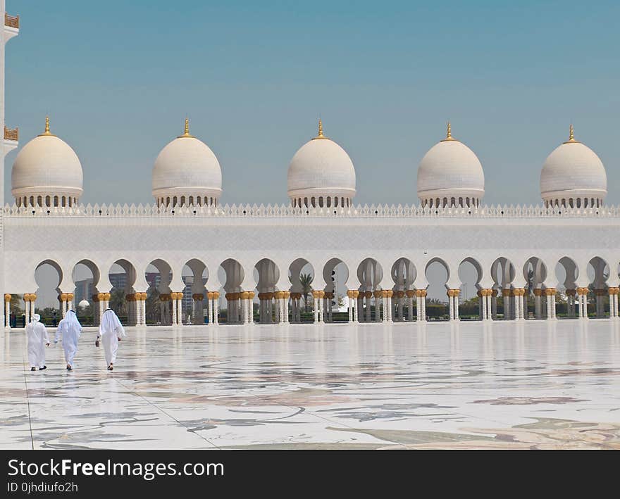 Three Men Walking in Front of a Dome Building