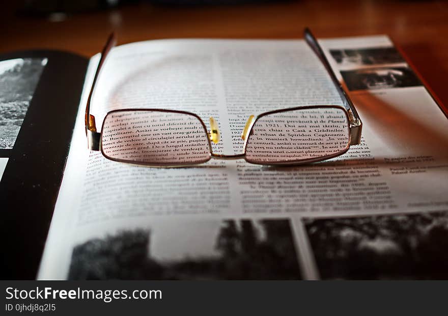 Eyeglasses With Gold-colored Frame on Opened Book