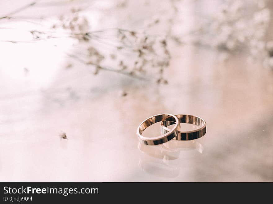 Two Silver-colored Rings on Beige Surface