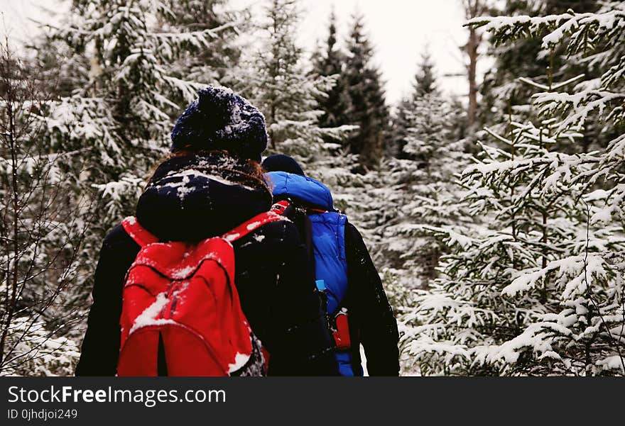 Two People Wearing Jacket And Red Backpack During Winter Season