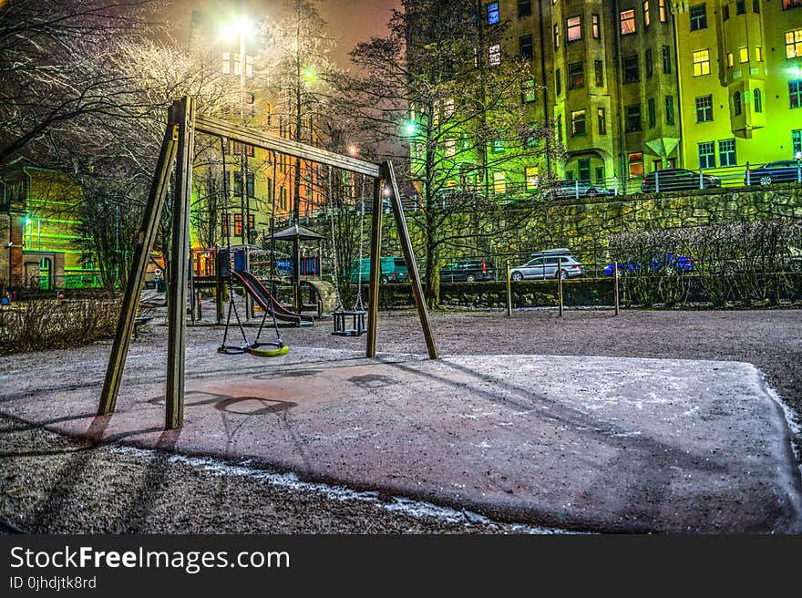 Playground Surrounded With Buildings And Cars