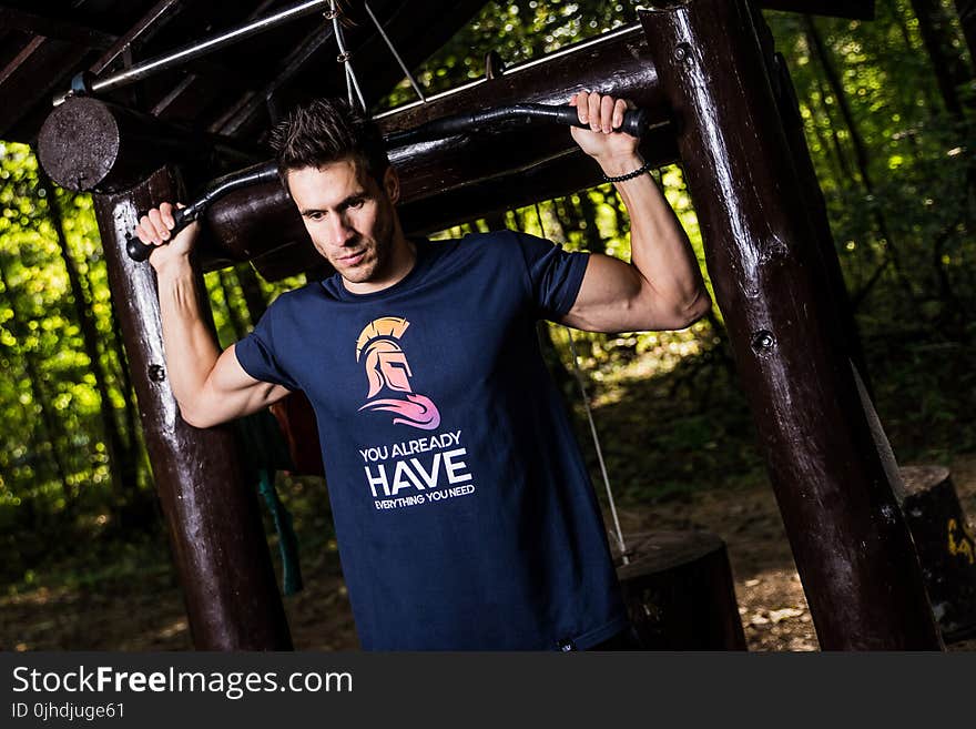 Man Wearing Blue Shirt Using Gym Equipments