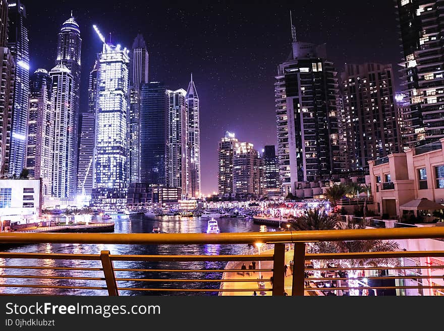 Boats on Body of Water Surrounded by High Rise Buildings