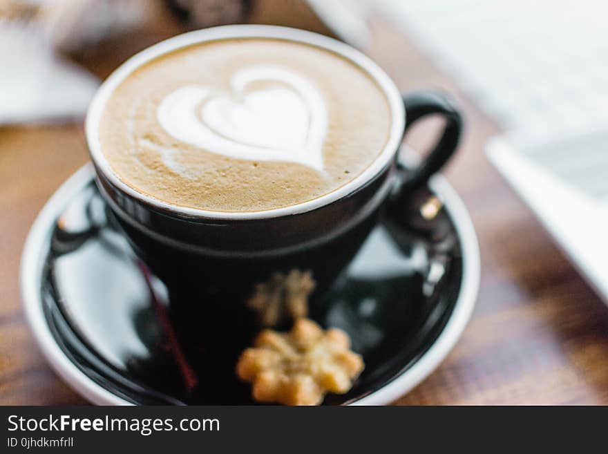 Black Ceramic Cup With Brown Liquid With Heart-shape on Black Ceramic Saucer