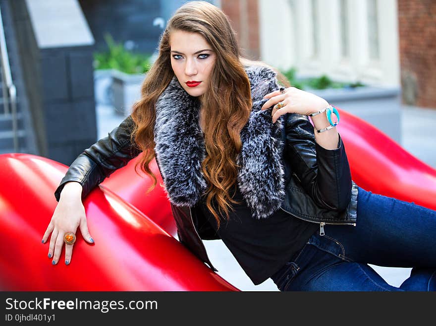 Closeup Photo of Woman Wearing Black Leather Fur-lined Jacket and Blue Denim Bottoms