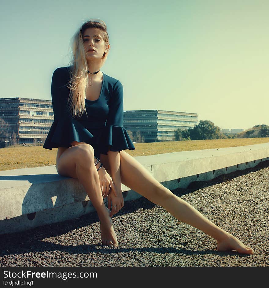 Woman Wears Black Scoop-neck Long-sleeved Blouse Seats on Grey Concrete Pavement