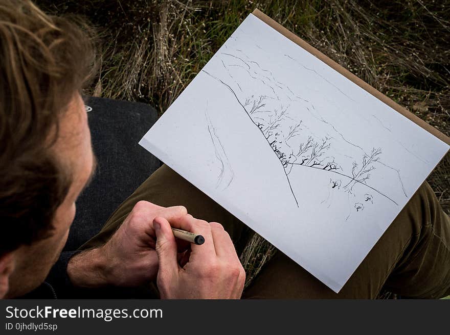 Man Drawing Mountain and Trees